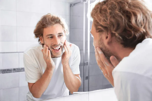 Νεαρός Άνδρας Πλύσιμο Του Προσώπου Σαπούνι Κοντά Καθρέφτη Στο Μπάνιο — Φωτογραφία Αρχείου