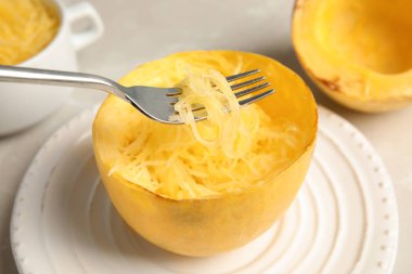 Etini pişmiş spagetti squash plaka üzerinde çatalla