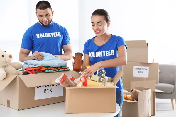 Jóvenes Voluntarios Recogiendo Donaciones Mesa Interiores — Foto de Stock