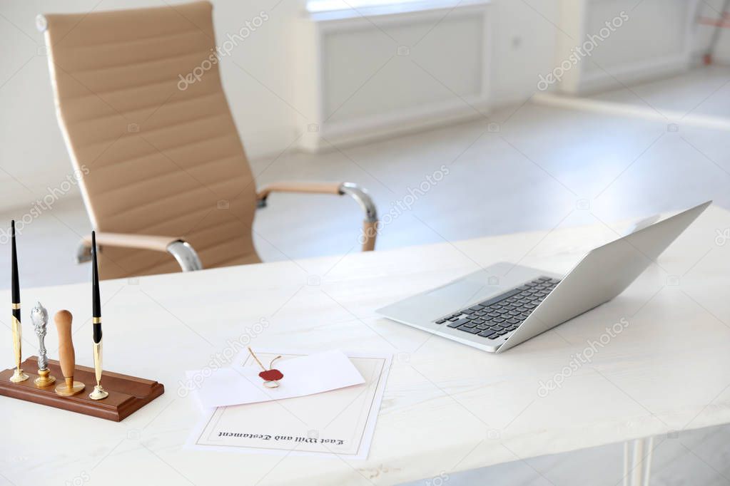 Wax stamps, laptop and documents on desk in notary's office