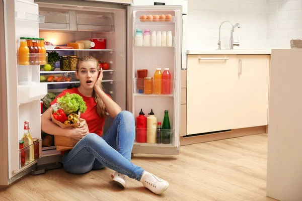 Jovem Mulher Emocional Sentado Perto Geladeira Cozinha — Fotografia de Stock