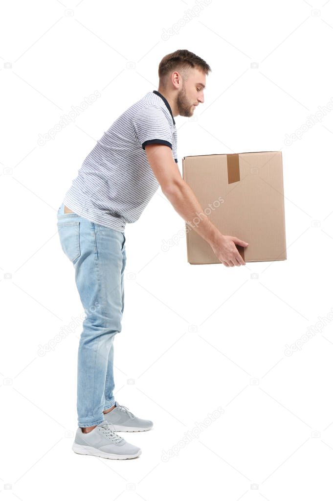 Full length portrait of young man lifting carton box on white background. Posture concept