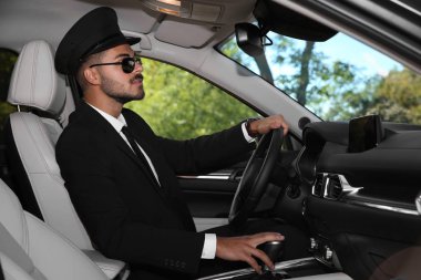 Young handsome driver in luxury car. Chauffeur service clipart