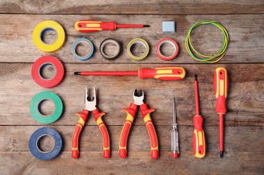 Tahta arka planda elektrikçi aletleri ile düz konum