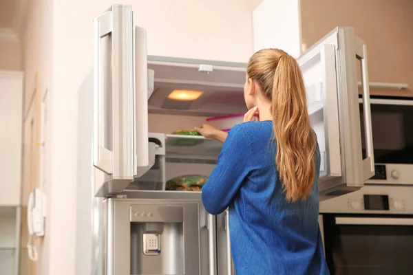 Νεαρή Γυναίκα Επιλέγοντας Τρόφιμα Στο Ψυγείο Στο Σπίτι — Φωτογραφία Αρχείου