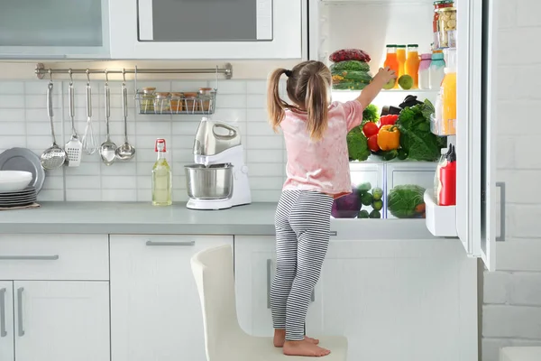 Χαριτωμένο Κορίτσι Λαμβάνοντας Apple Από Ψυγείο Στην Κουζίνα — Φωτογραφία Αρχείου