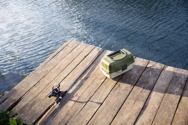 タックル ボックス リバーサイドで木製の桟橋での釣りのためのロッド レクリエーション活動 — ストック写真