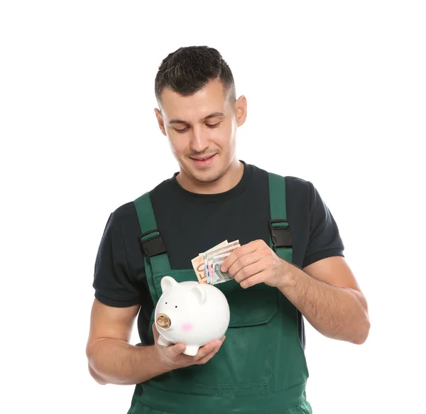 Portrait Male Worker Uniform Putting Money Piggy Bank White Background — kuvapankkivalokuva