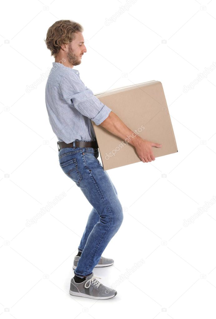 Full length portrait of young man carrying heavy cardboard box on white background. Posture concept