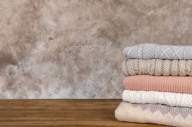 Ahşap masa üzerinde sıcak sonbahar elbise yığını. Metin için yer