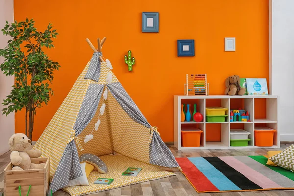 Cozy kids room interior with play tent and toys