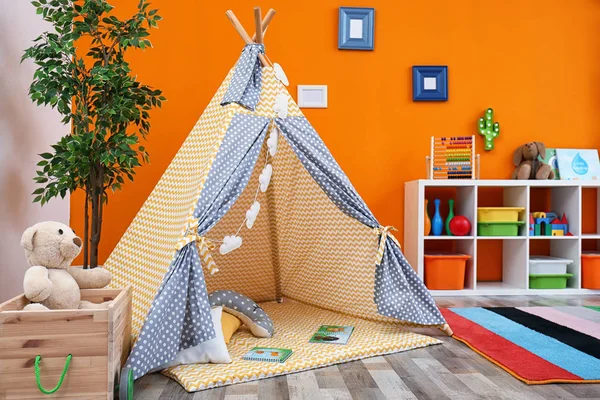 Cozy kids room interior with play tent and toys