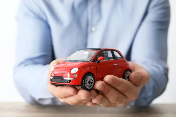 おもちゃの車 クローズ アップを保持している男性の保険エージェント — ストック写真