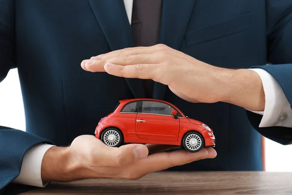 Versicherungsvertreter Hält Spielzeugauto Über Tisch Konzentriert Sich Auf Hände — Stockfoto