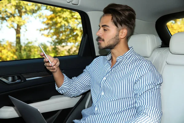 Ung Vacker Man Med Laptop Med Telefon Bilen — Stockfoto