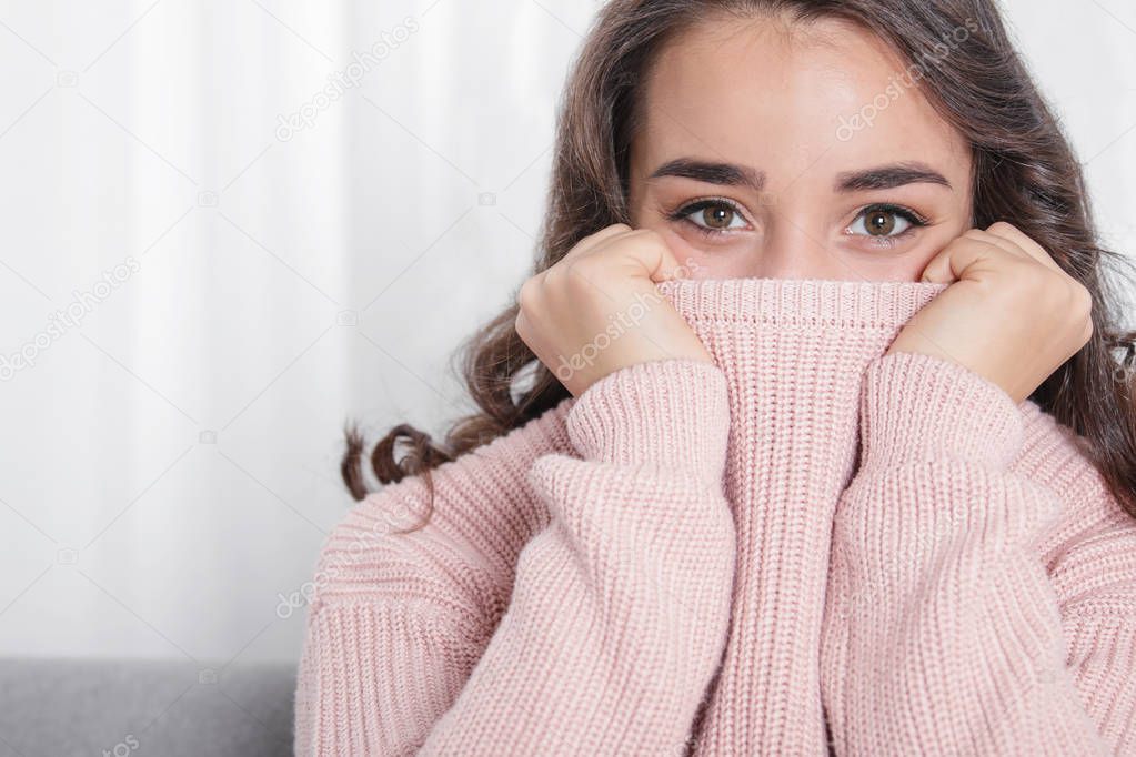 Young woman in warm sweater at home