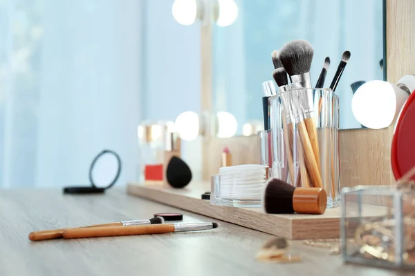 Organizer with cosmetic products for makeup on table near mirror. Space for text