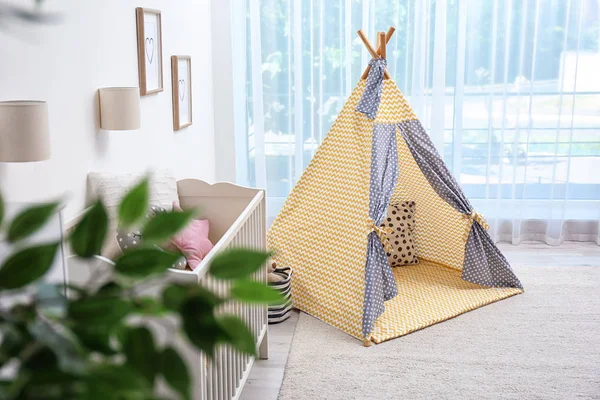 Cozy baby room interior with play tent and toys