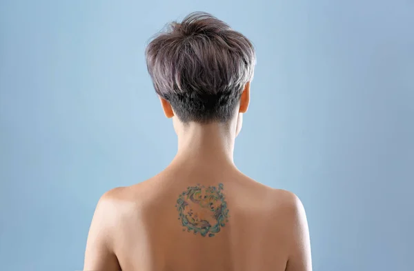 Tatuagem Bonita Nas Costas Femininas Contra Fundo Cor — Fotografia de Stock