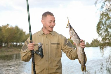 Adam çubuk ve riverside adlı balık yakalamak. Eğlence etkinliği