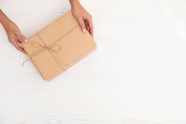 Ahşap arka plan üzerinde üstten görünüm parsel ve metin için yer tutan kadın