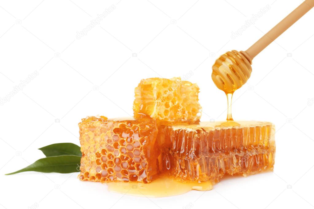 Pouring honey onto fresh combs on white background