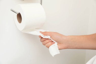 Beyaz duvar, portre rulo yuvasını tuvalet kağıdı alarak kadın