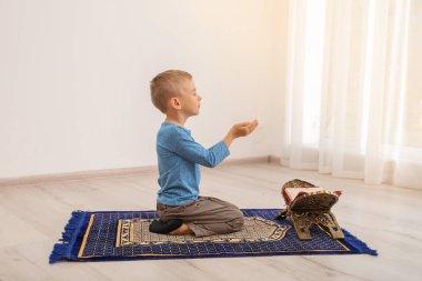 Kur'an halıya kapalı dua ile küçük Müslüman çocuk
