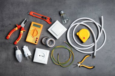 Gri arka plan üzerinde elektrikçi araçlarıyla düz yatıyordu kompozisyon