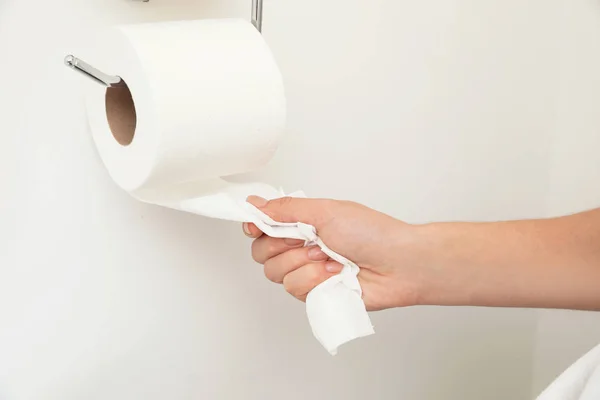 Kobieta Przyjmuje Papier Toaletowy Uchwyt Białej Ścianie Zbliżenie — Zdjęcie stockowe