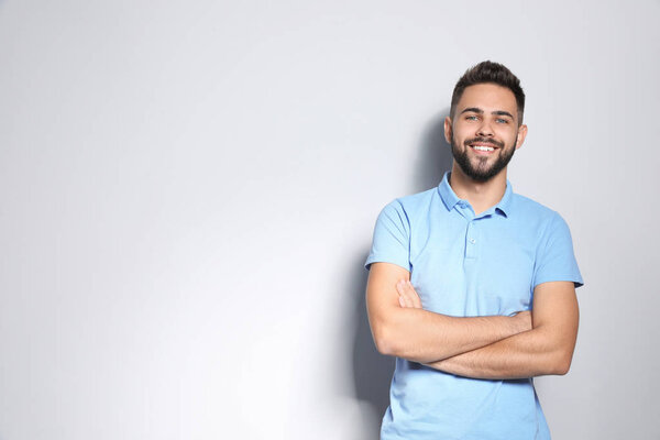 Portrait of handsome young man against light background. Space for text