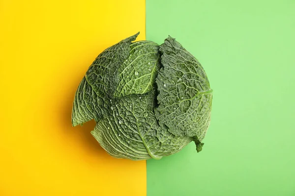 Fresh green savoy cabbage on color background, top view