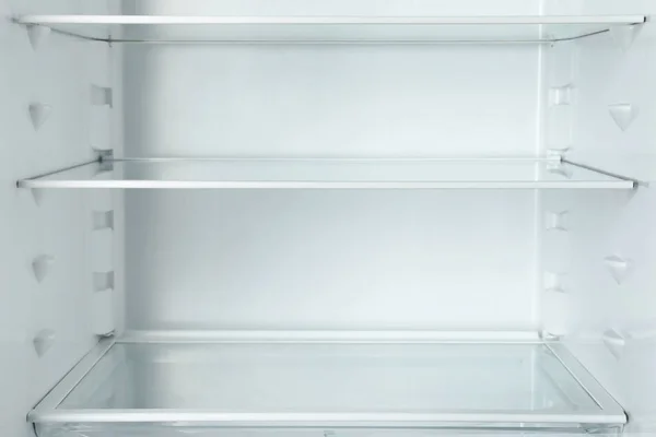 Modern open refrigerator with empty shelves, closeup