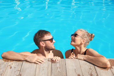 Mutlu genç çift Resort'ta yüzme havuzunda