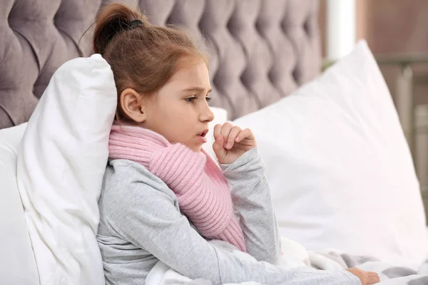 Little girl suffering from cough and cold in bed at home