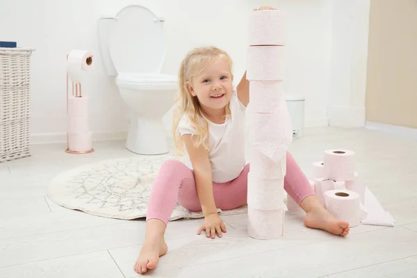 トイレのトイレット ペーパーで遊ぶかわいい女の子 — ストック写真