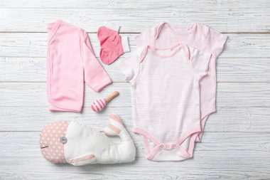 Ahşap arka plan üzerinde şık bebek giysileri ile düz yatıyordu kompozisyon