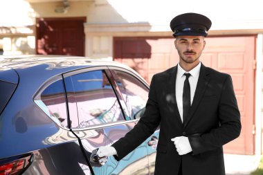 Lüks arabanın yakınında duran genç yakışıklı sürücü. Şoför Servisi
