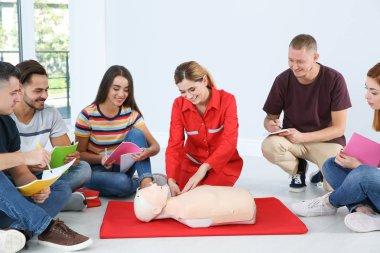 CPR manken ilkyardım sınıfı kapalı gösteren eğitmen