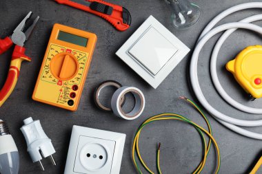 Gri arka plan üzerinde elektrikçi araçlarıyla düz yatıyordu kompozisyon