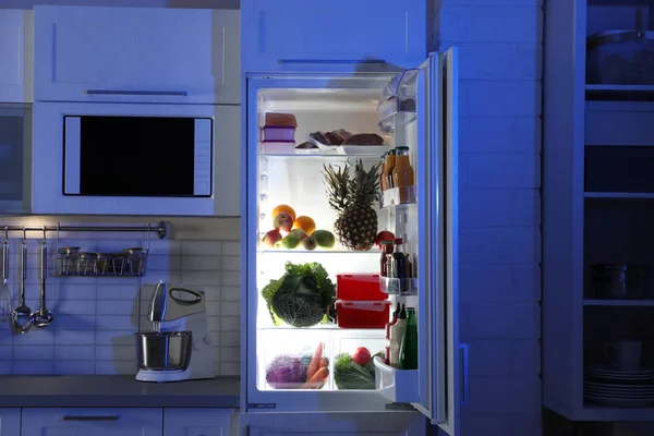 Открытый Холодильник Полный Продуктов Стильном Интерьере Кухни Ночью — стоковое фото