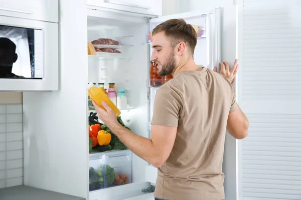 Homme Prenant Bouteille Avec Jus Hors Réfrigérateur Dans Cuisine — Photo