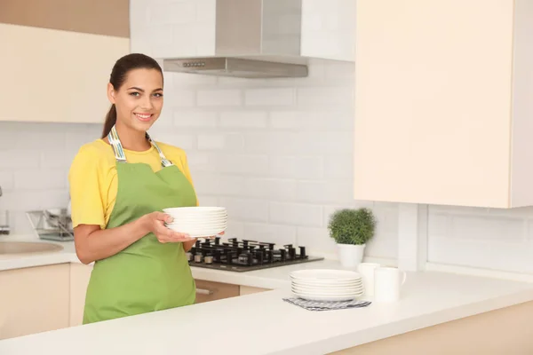 Jovem Segurando Pilha Pratos Limpos Cozinha — Fotografia de Stock