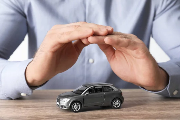 Male Insurance Agent Covering Toy Car Table Closeup — Stock Photo, Image
