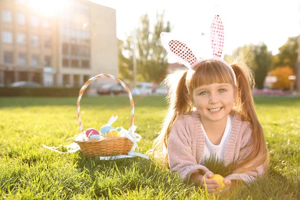 Niedliches Kleines Mädchen Mit Hasenohren Und Korb Mit Ostereiern Park — Stockfoto