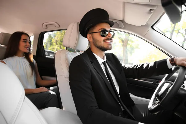 Young businesswoman with handsome driver in luxury car