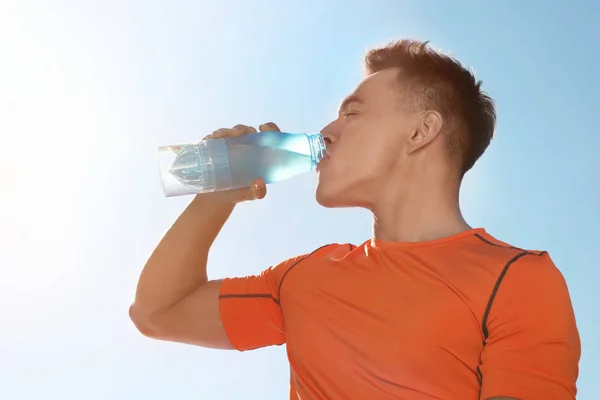 Joven Deportista Bebiendo Agua Botella Contra Cielo Azul Día Soleado — Foto de Stock