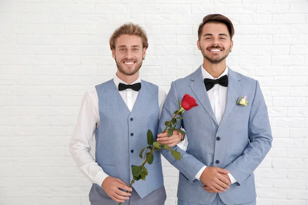 Lycklig Nygift Homosexuella Par Med Blomma Mot Vit Vägg — Stockfoto