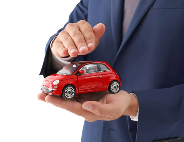 Versicherungsvertreter Hält Spielzeugauto Auf Weißem Hintergrund Nahaufnahme — Stockfoto