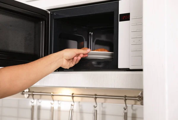 Jovem Colocando Prato Com Croissants Forno Microondas Close — Fotografia de Stock